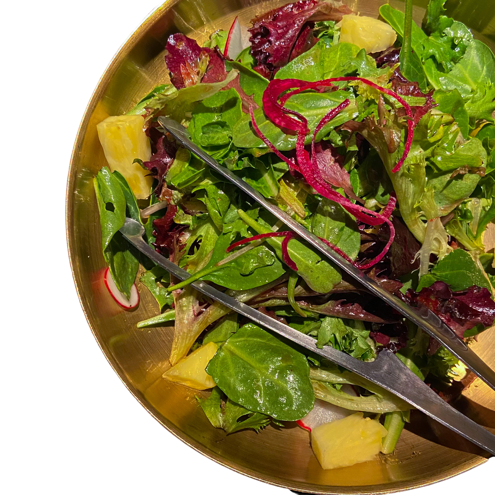 a gold bowl filled with a bright green salad with beets, cabbage, and radishes