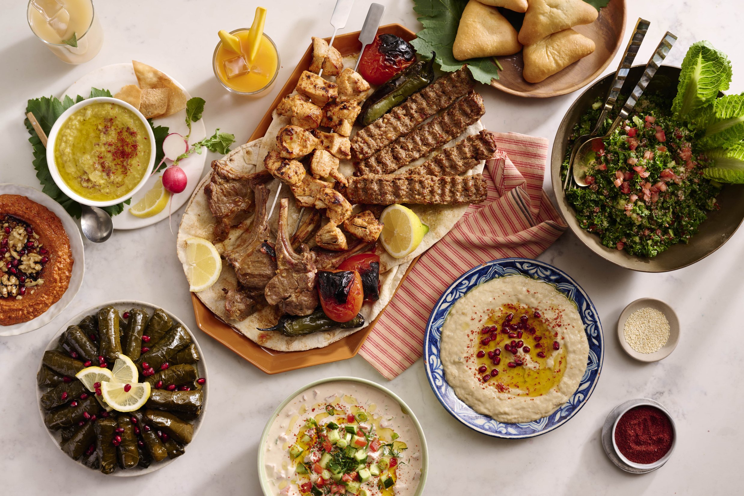 various types of Mediterranean food are displayed on a table